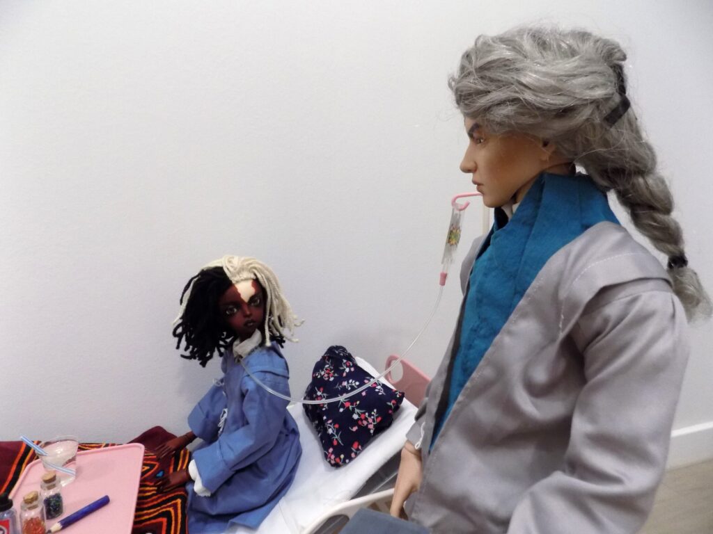 Twp dolls in a hospital room, one being the patient, the other the nurse.