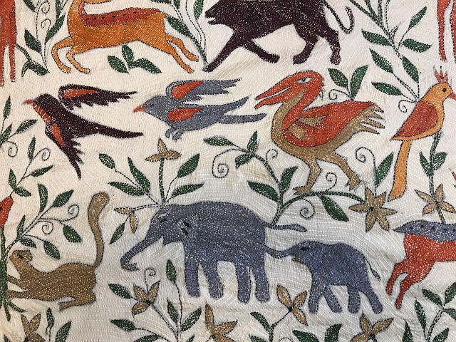 White kantha embroidery with colorful animals, including elephants, birds, and deer.